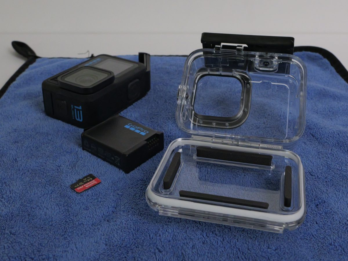 Questa foto mostra una custodia originale GoPro aperta dopo l'imemrisone, si vedono anch ela GoPro Hero13, la batteria e la scheda microSD