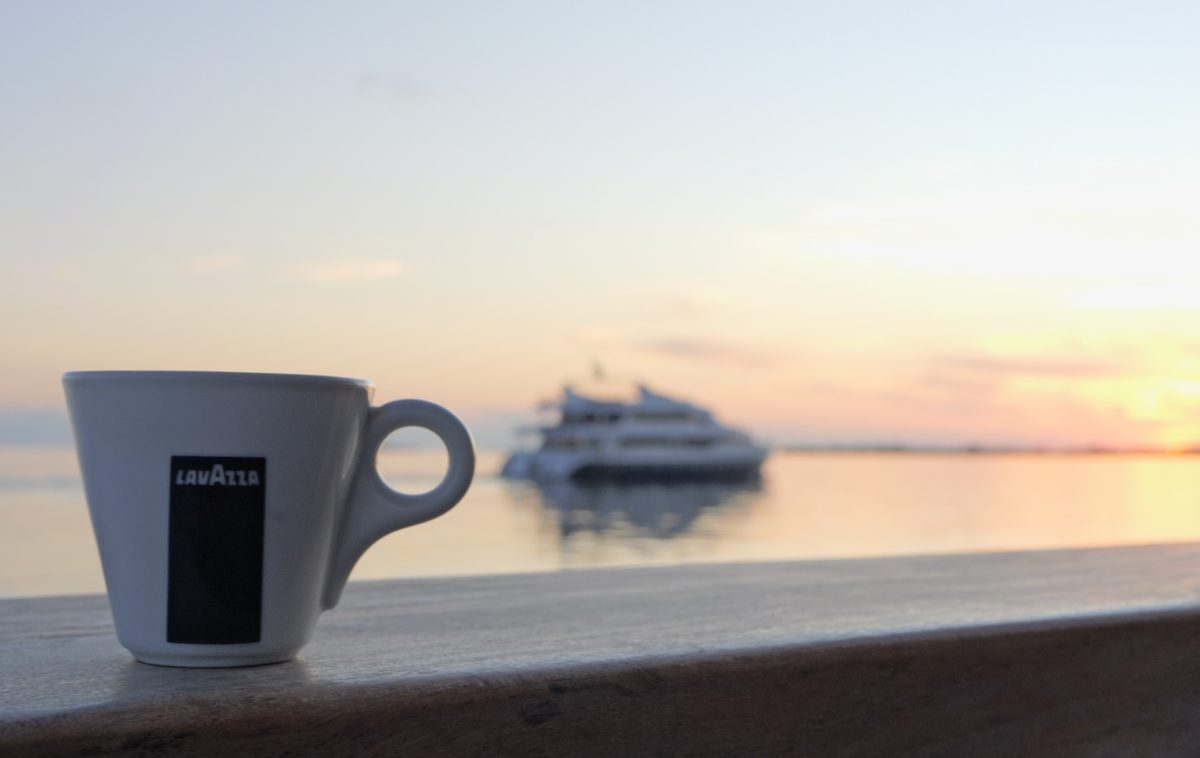 Un Tazza di caffè Lavazza con sullo sfondo una spettacolare alba Maldiviana.